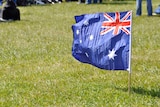 Australian flag planted in the grass.