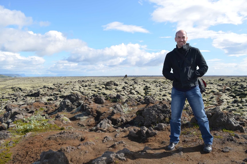 Chris stands in moss covered lava fields in southern Iceland for story on winter holidays