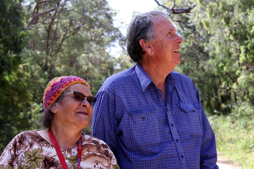 A woman and man stand side by side smiling.