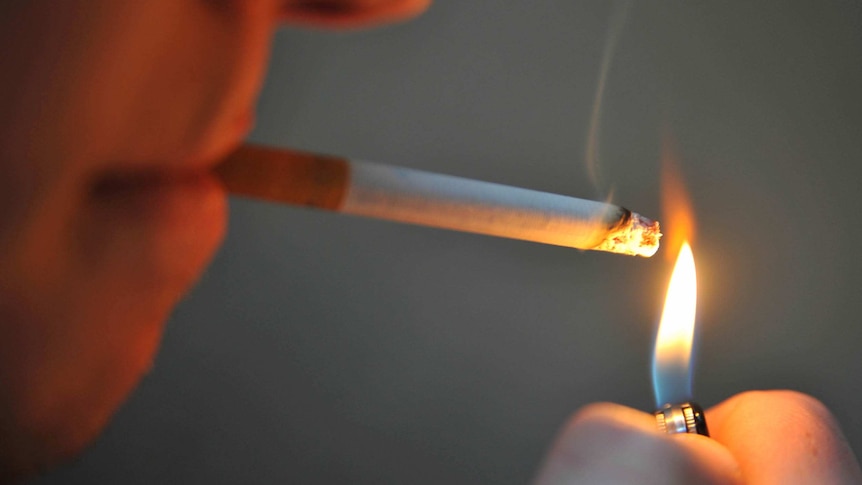 A man lights a cigarette.