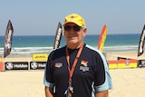 Keith Caldwell stands on a beach wearing a hat, sunglasses and a t-shirt.