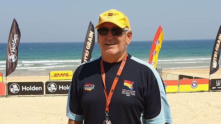 Keith Caldwell stands on a beach wearing a hat, sunglasses and a t-shirt.