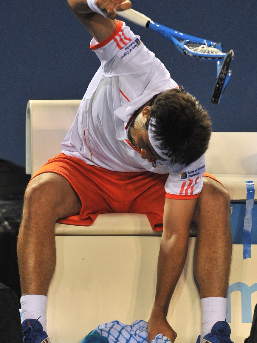 Take that ... Marcos Baghdatis smashes an already destroyed racquet during the 2012 Australian Open