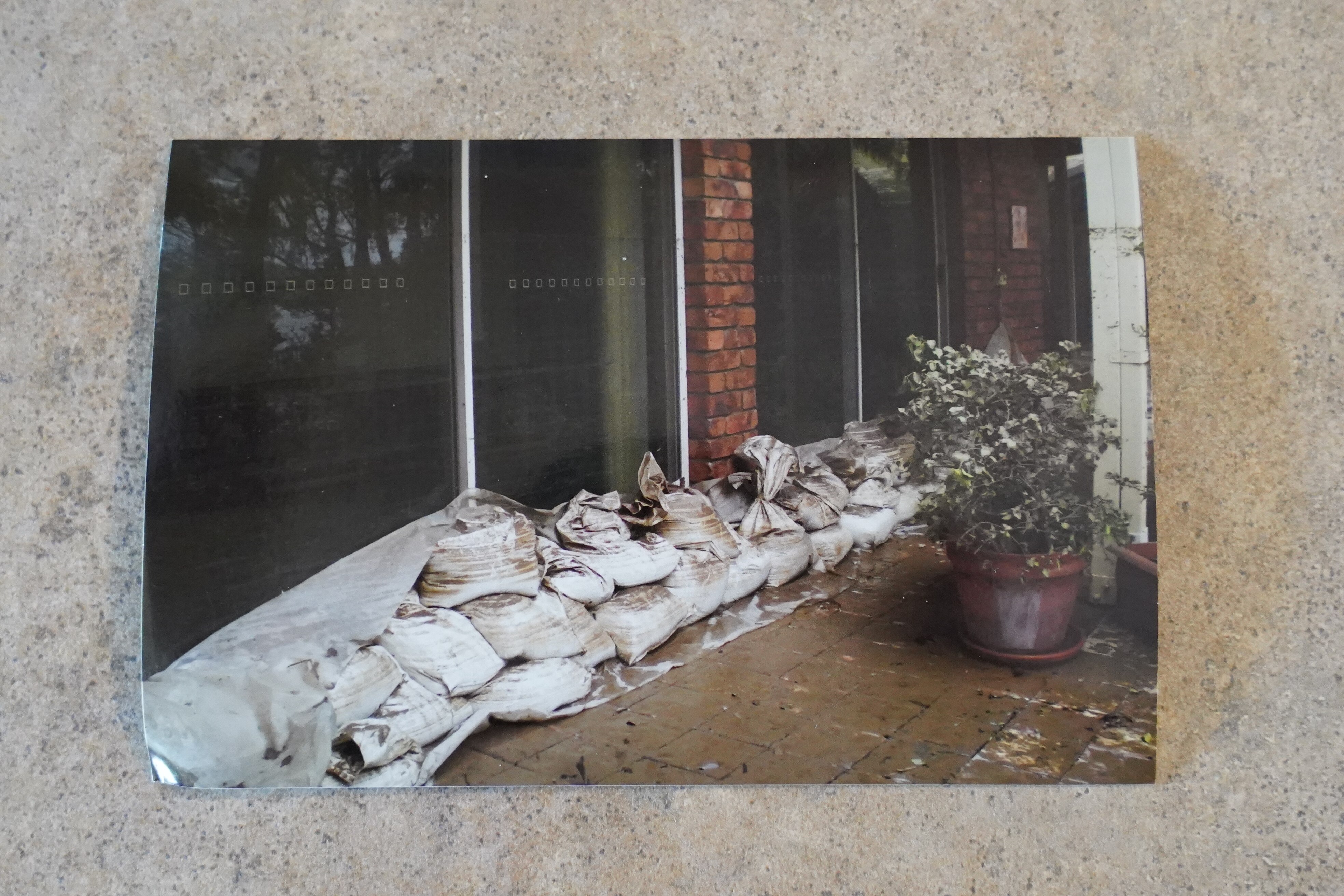 Bolsos fuera de una puerta corredera de una casa de ladrillos. El agua de la inundación ha disminuido. 