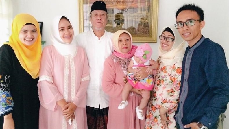 Dea Winnie Pertiwi stands with her parents and three sisters and her eldest sister's husband.