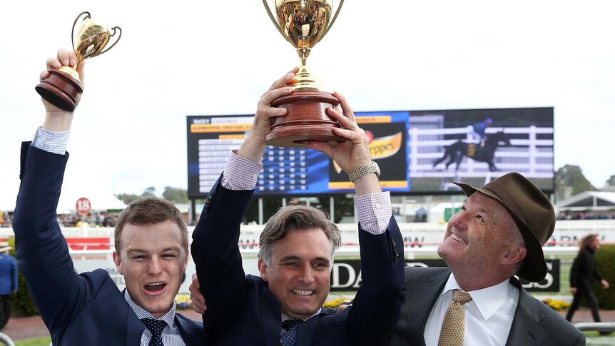 Trainers (L to R) Ben Hayes, Tom Dabernig and David Hayes celebrate Boom Time's Caulfield Cup win.