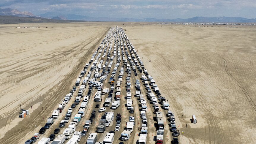 Multiple lines of traffic slowly drive through the Nevada desert.