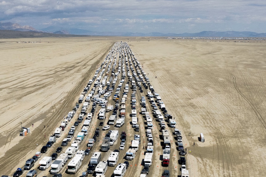 Multiple lines of traffic slowly drive through the Nevada desert.