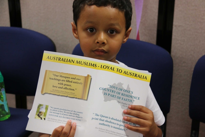 A close-up shot of the child holding a leaflet