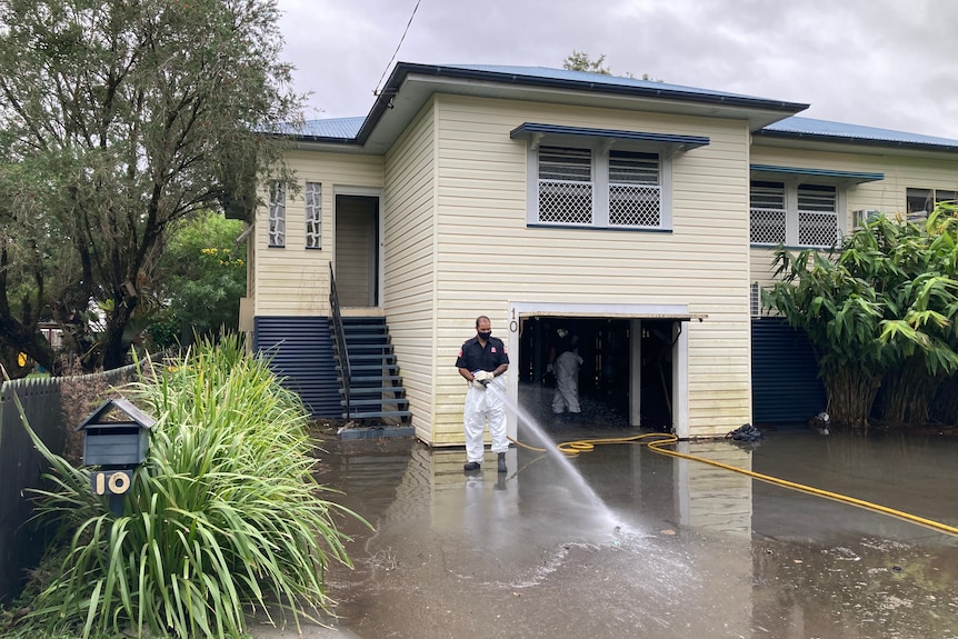 NSW Fire and Rescue crews begin hosing out a flood affected home in Lismore.