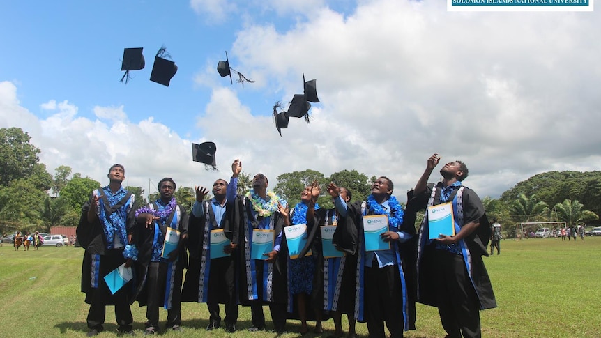 graduating students throw their hats in the air 
