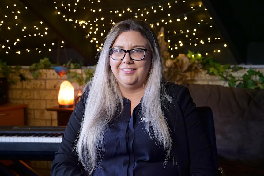 Woman sitting in a room with fairy lights on the ground behind