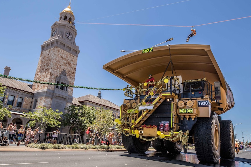 Un camion minier roule dans la rue dans le cadre d'un défilé.  