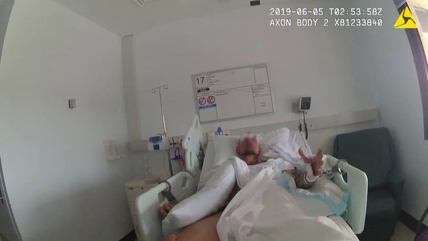 Blurred image of a man handcuffed in a hospital bed