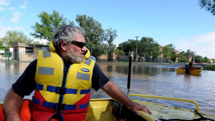 An SES flood boat ferries supplies to isolated communities.