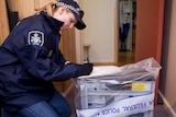 A policewoman secures evidence at David Cecil's property.