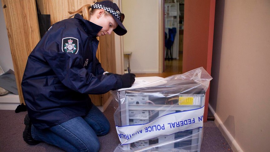 A policewoman secures evidence at David Cecil's property.