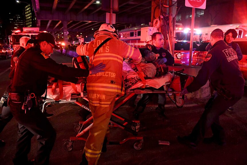 Image of paramedics and firefighters performing CPR on a person laying on a gurney