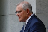 Scott Morrison  gestures as he speaks at a lecturn during a media briefing, as Josh Frydenberg looks on