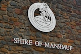 A brick wall with a shire office logo in the middle and 'Shire of Manjimup' written underneath 