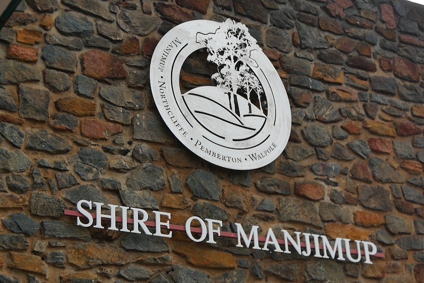 A brick wall with a shire office logo in the middle and 'Shire of Manjimup' written underneath 