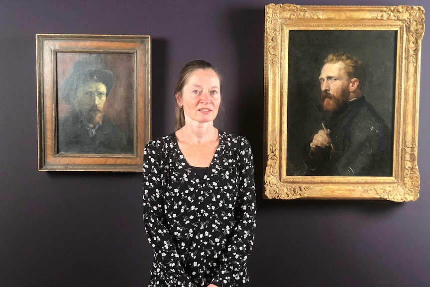 Van Gogh Museum curator Nienke Bakker standing between a Van Gogh self-portrait (l) and a Van Gogh portrait by John Russell (r)