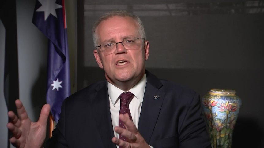 Prime Minister Scott Morrison wears a suit and tie and glasses.
