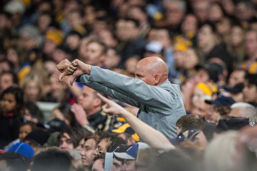 Footy fan gestures to the umpire
