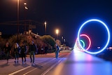Young people walk over a bridge at night