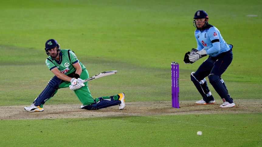 Andrew Balbirnie plays a sweep shot on one knee as the wicketkeeper watched on