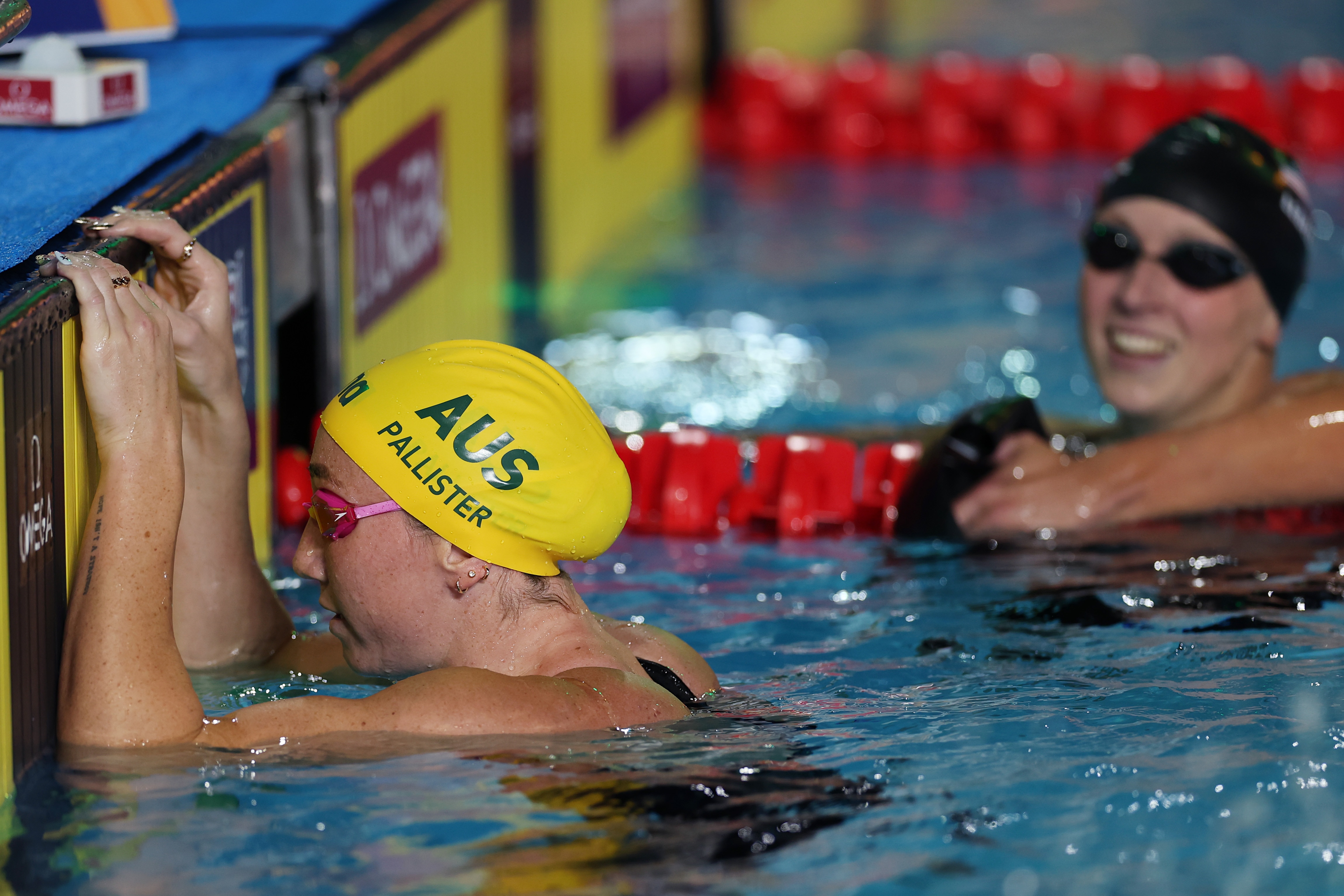 Katie Ledecky watches Lani Pallister as they sit in the pool after the 800m freestyle at the Pan Pacs.