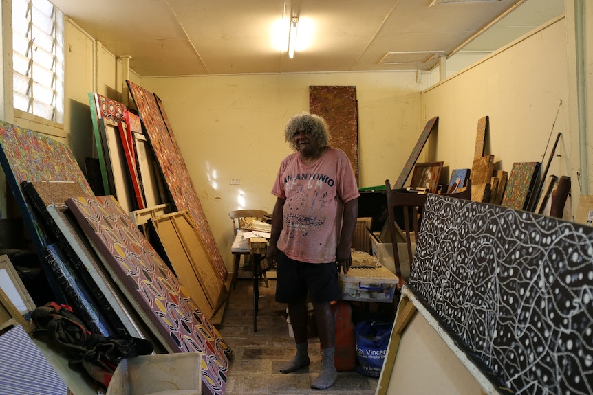 Digby Moran in his studio, surrounded by many paintings