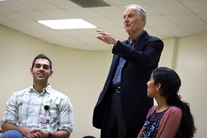 Alan Alda with two workshop participants.