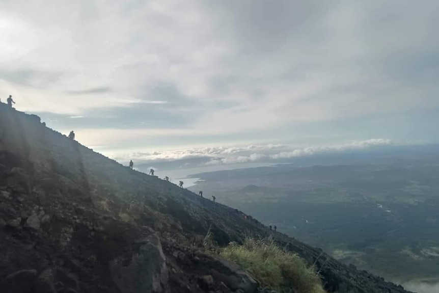 Rescue crews climbing a steep volcano