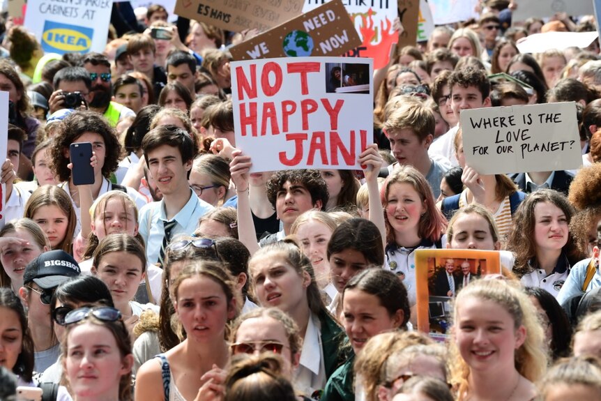 In a large crowd of protester, someone holds a sign that reads "Not happy Jan".