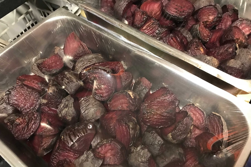 A silver tray holding roasted beetroot.