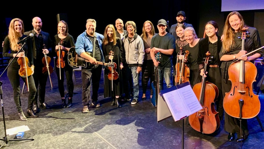 Phil Walleystack and the orchestra musicians lined up on stage.