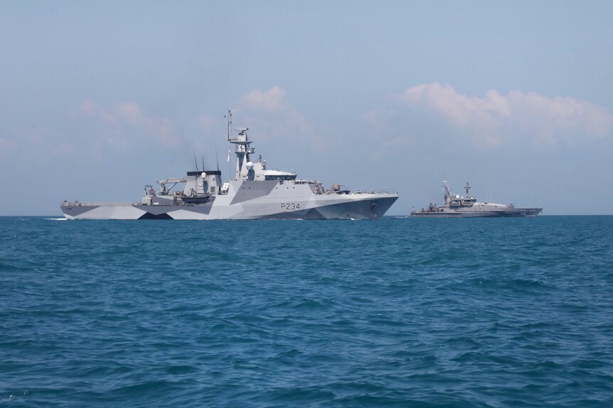 Two sharp-looking grey warships float on a deep blue ocean.