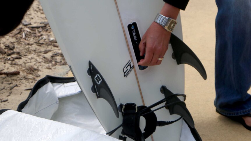 Fitting a shark repellent device to a surfboard