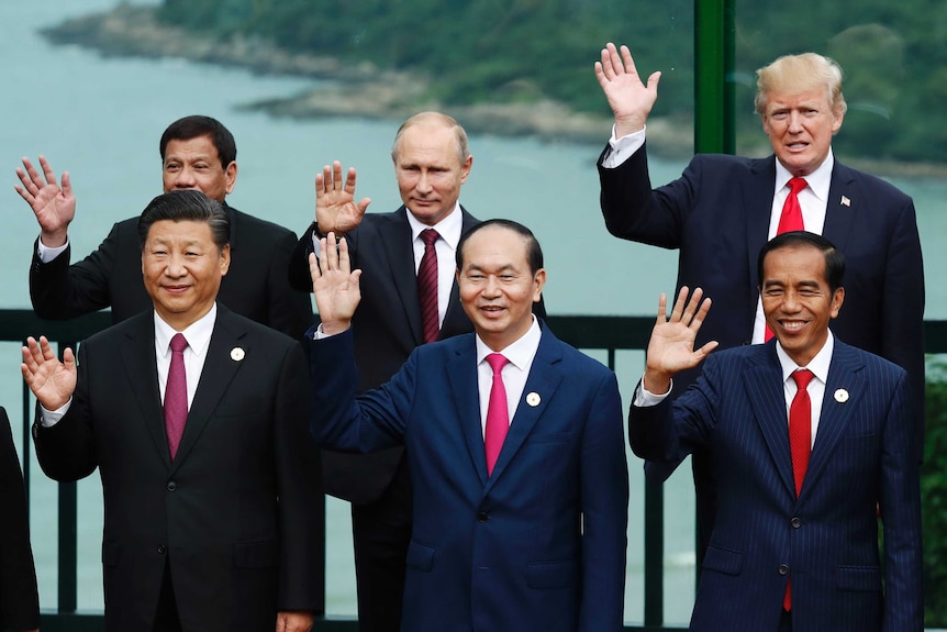World leaders including Vladimir Putin and Donald Trump pose for a photograph.