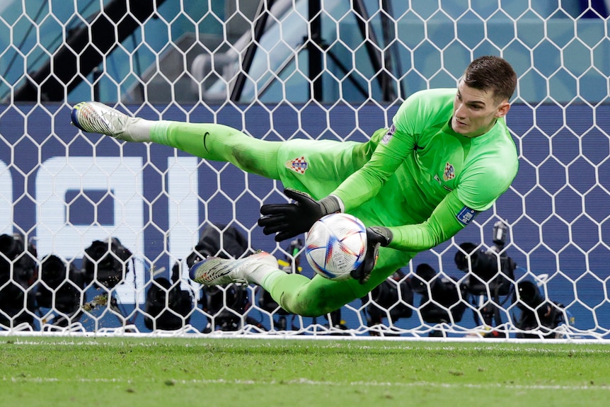 Croatia goalkeeper Dominic Livakovic stops a shot during a penalty shootout against Japan at the Qatar World Cup.