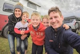 Ryan and Amy Murphy pose with their three young boys in front of their camper and four-wheel-drive