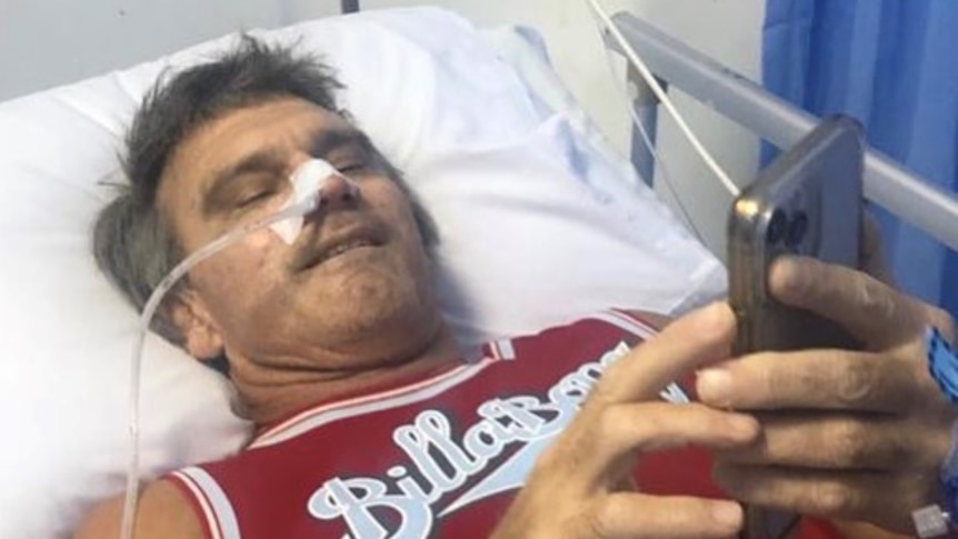 A man lies in hospital with a tube coming from his nose