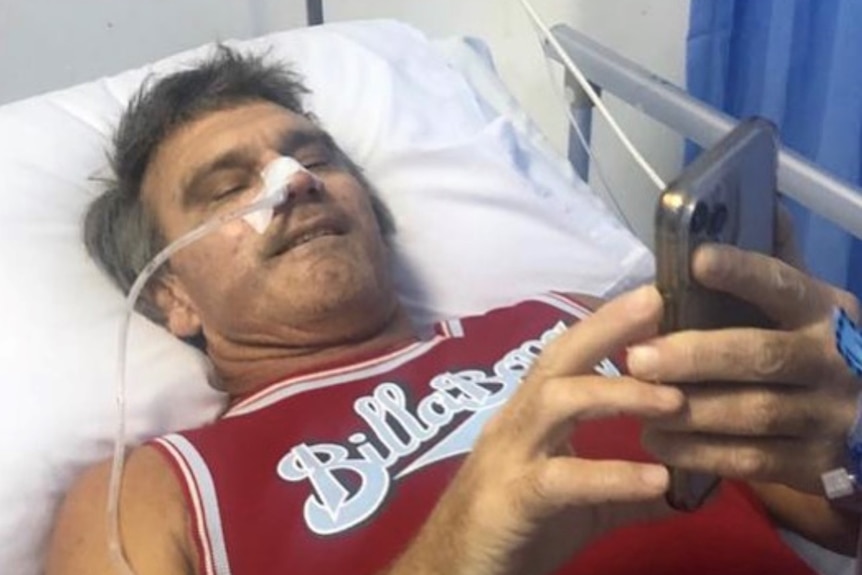 A man lies in hospital with a tube coming from his nose