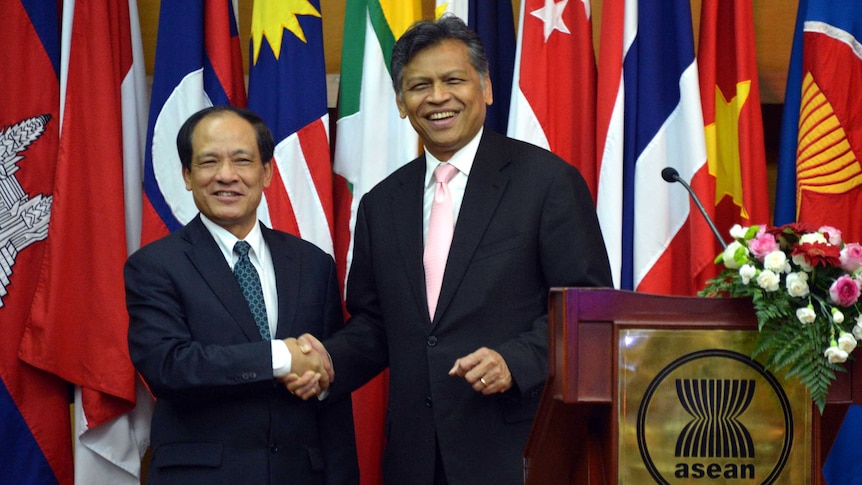 ASEAN secretary general Le Luong Minh shakes hands with his predecessor Surin Pitsuwan.