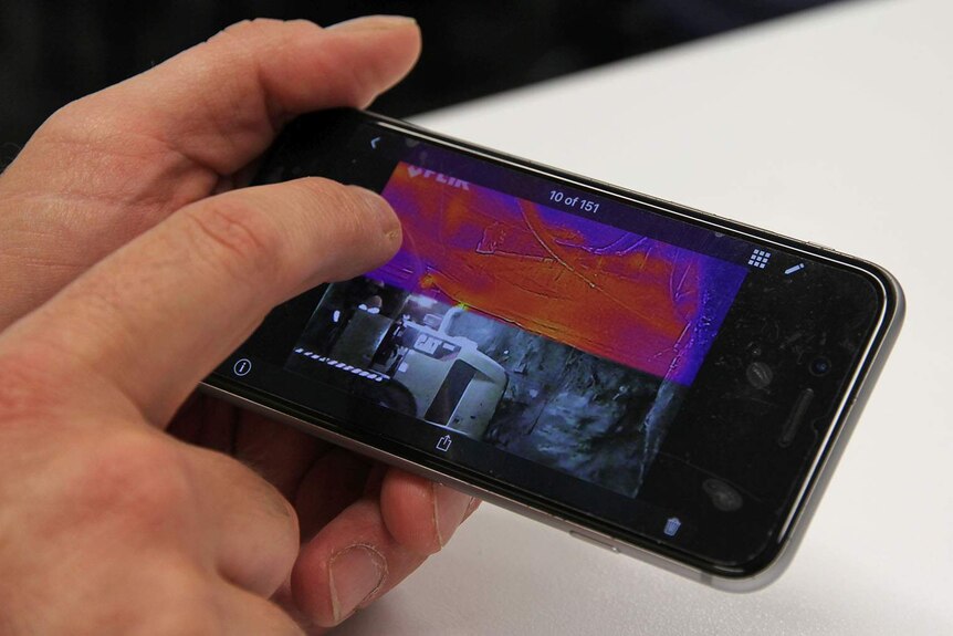 An interactive map on a phone shows the surface temperatures of a worksite.
