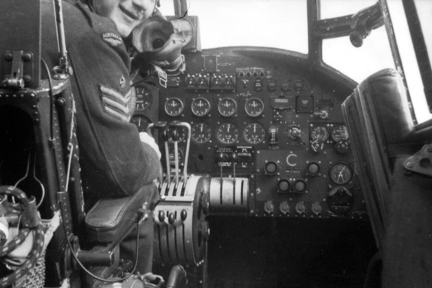 Flight Sergeant George Hayes partially visible in the cockpit of a Lancaster bomber of 460 Squadron RAAF.