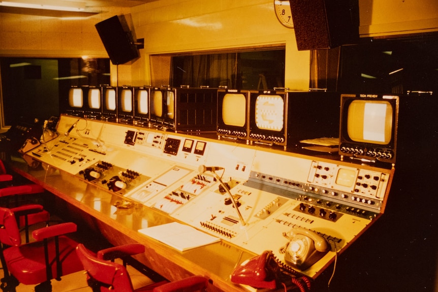 An historical photo of the ABC Darwin control room. Old TVs and retro telephones are on a dashboard.