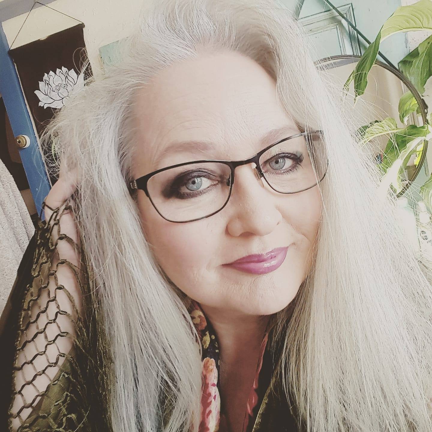 Sarah Baker has silver hair and wears glasses