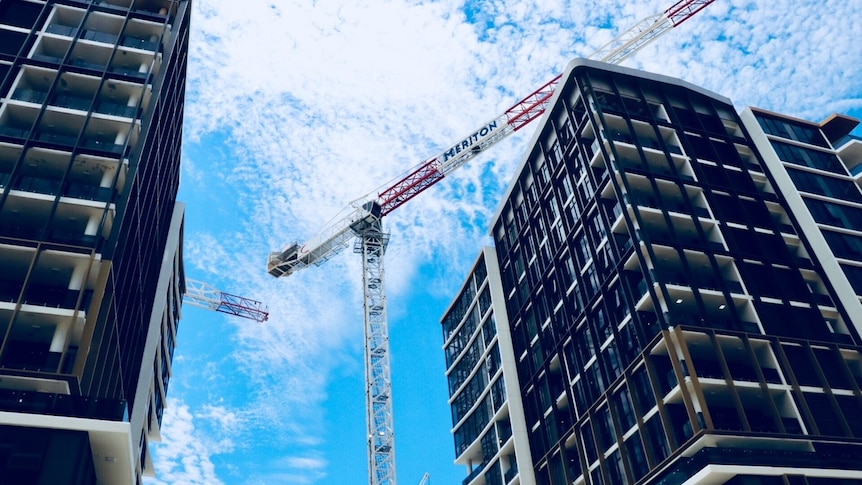 Two apartment buildings with a crane in the middle